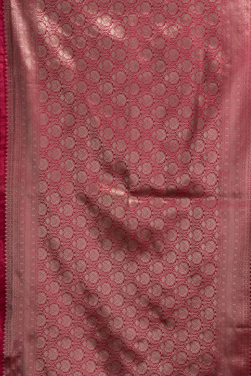 Pink fabric with a subtle pattern, possibly a saree or a similar type of fabric.