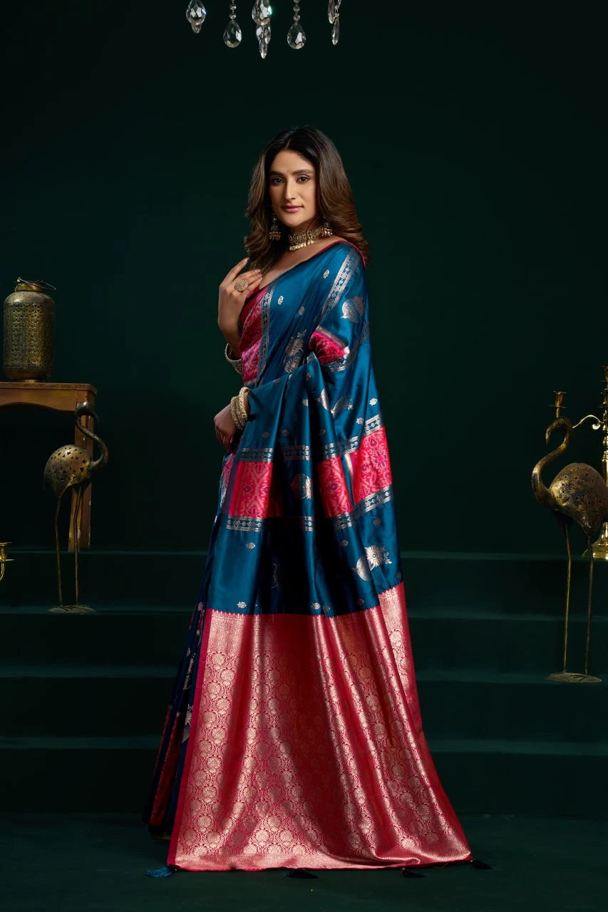 Woman wearing a blue and red saree with a dark background