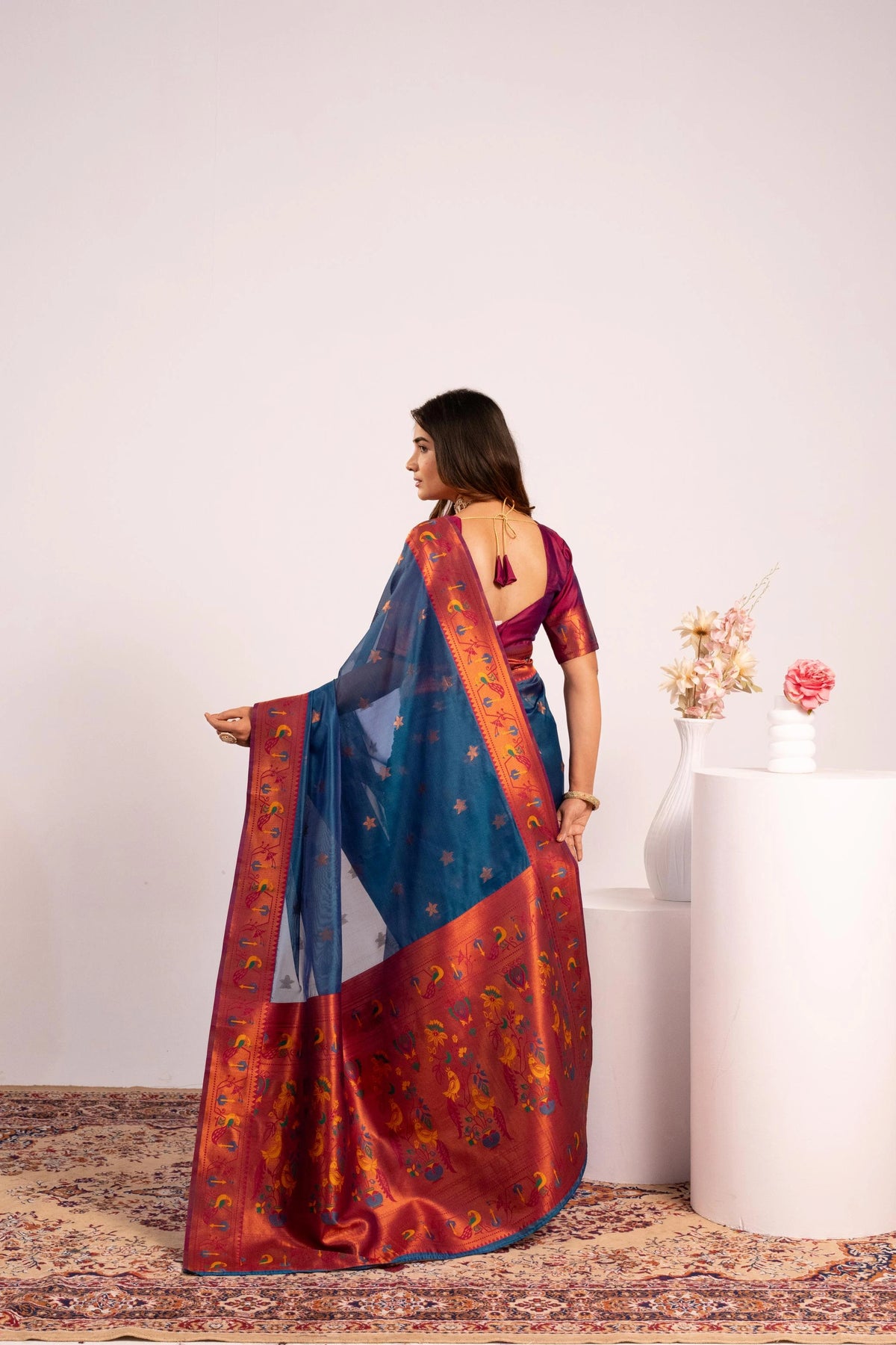 Woman holding a colorful saree with a white background