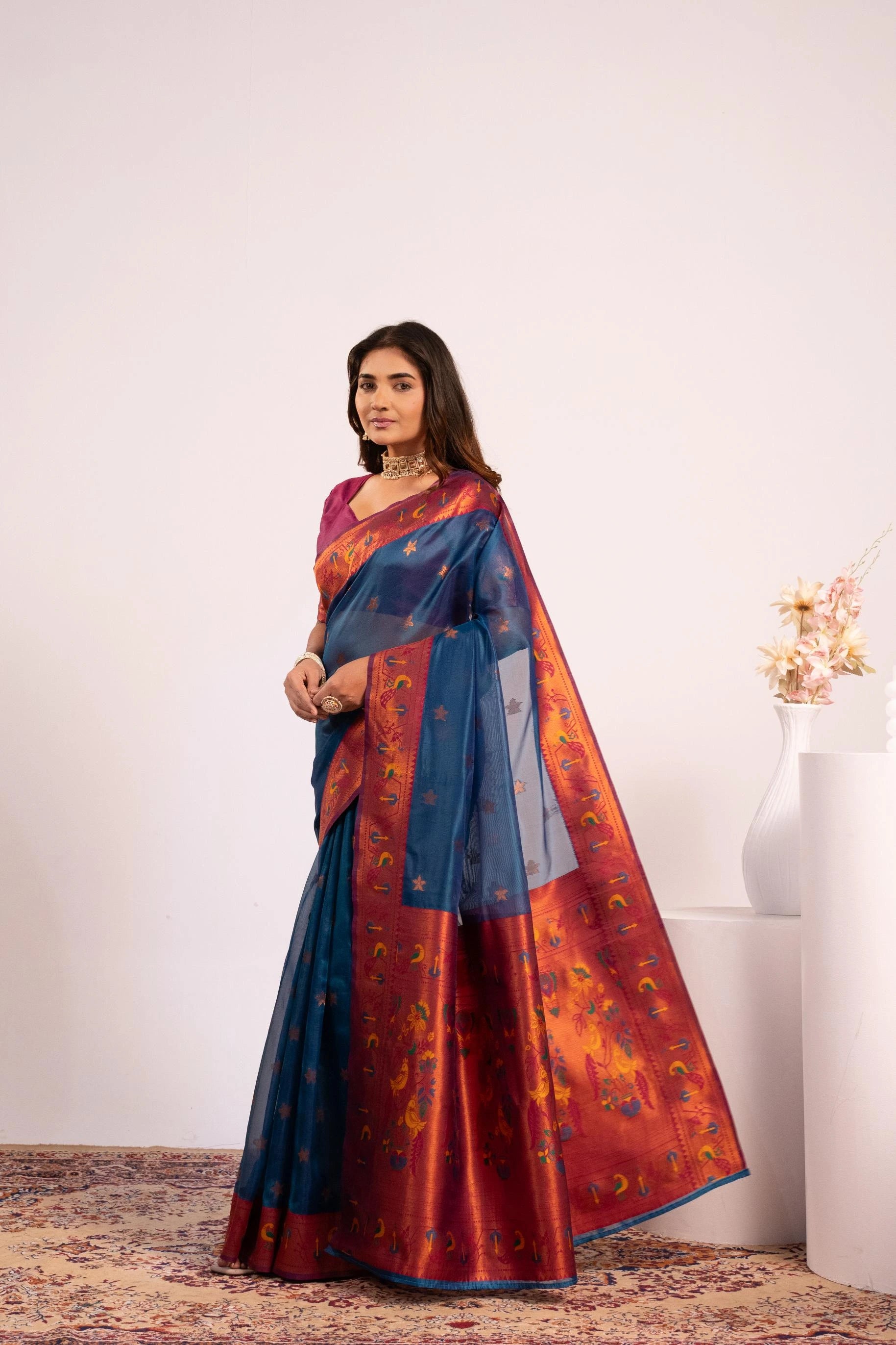 Woman wearing a blue and red saree with a white background