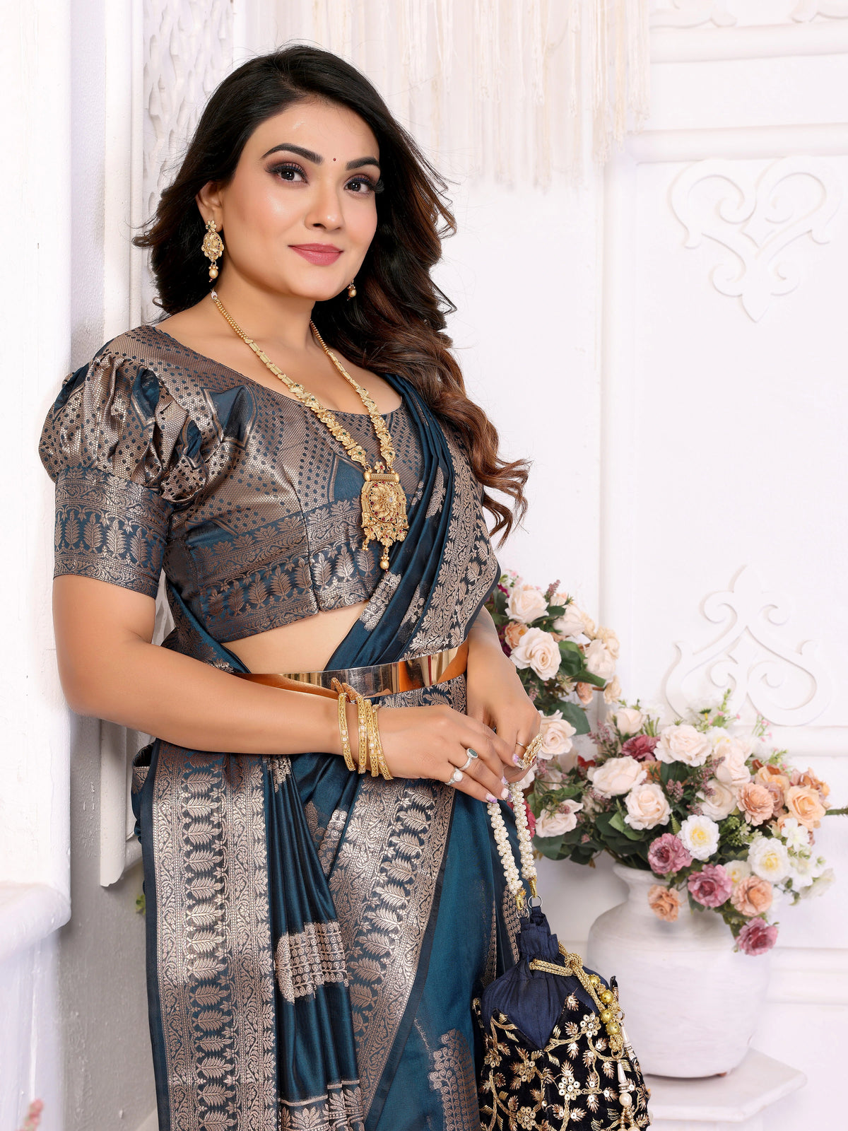 Woman in traditional attire with floral decorations in the background