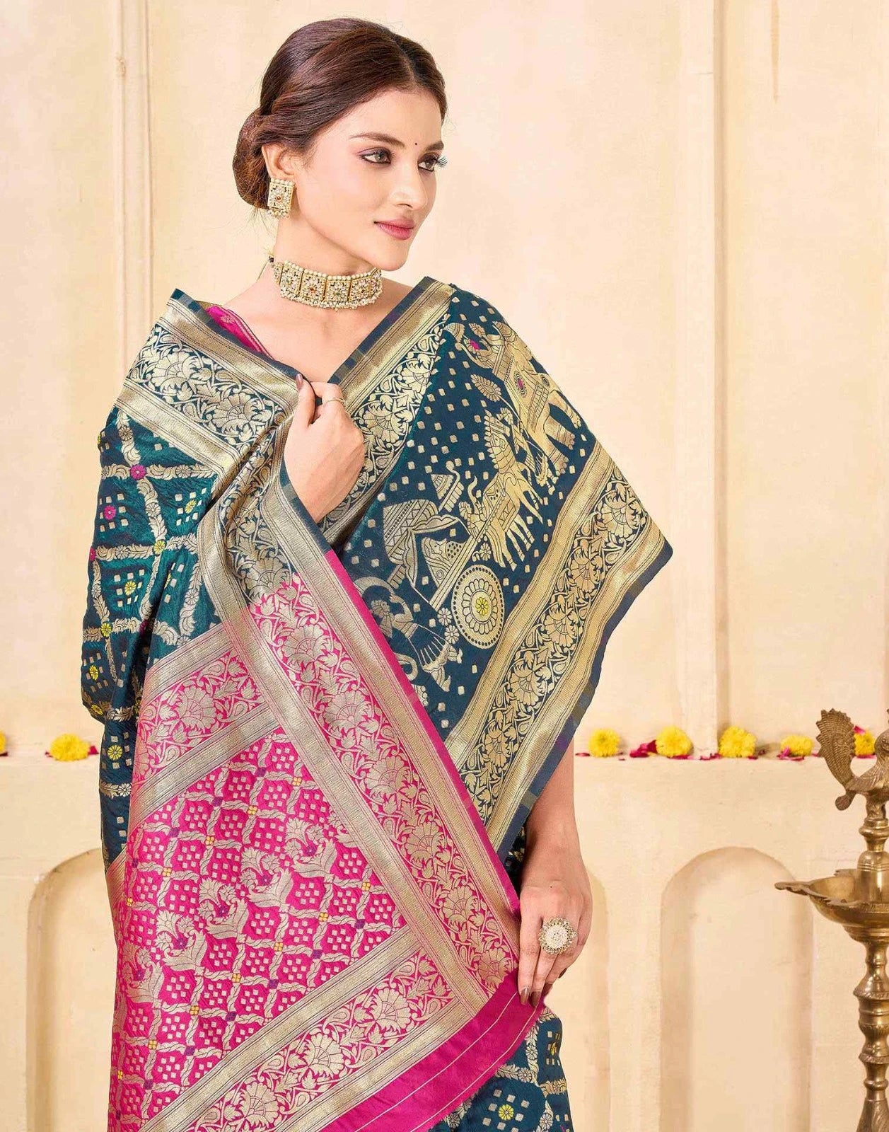 Woman wearing a traditional saree with a blue and pink design against a beige background