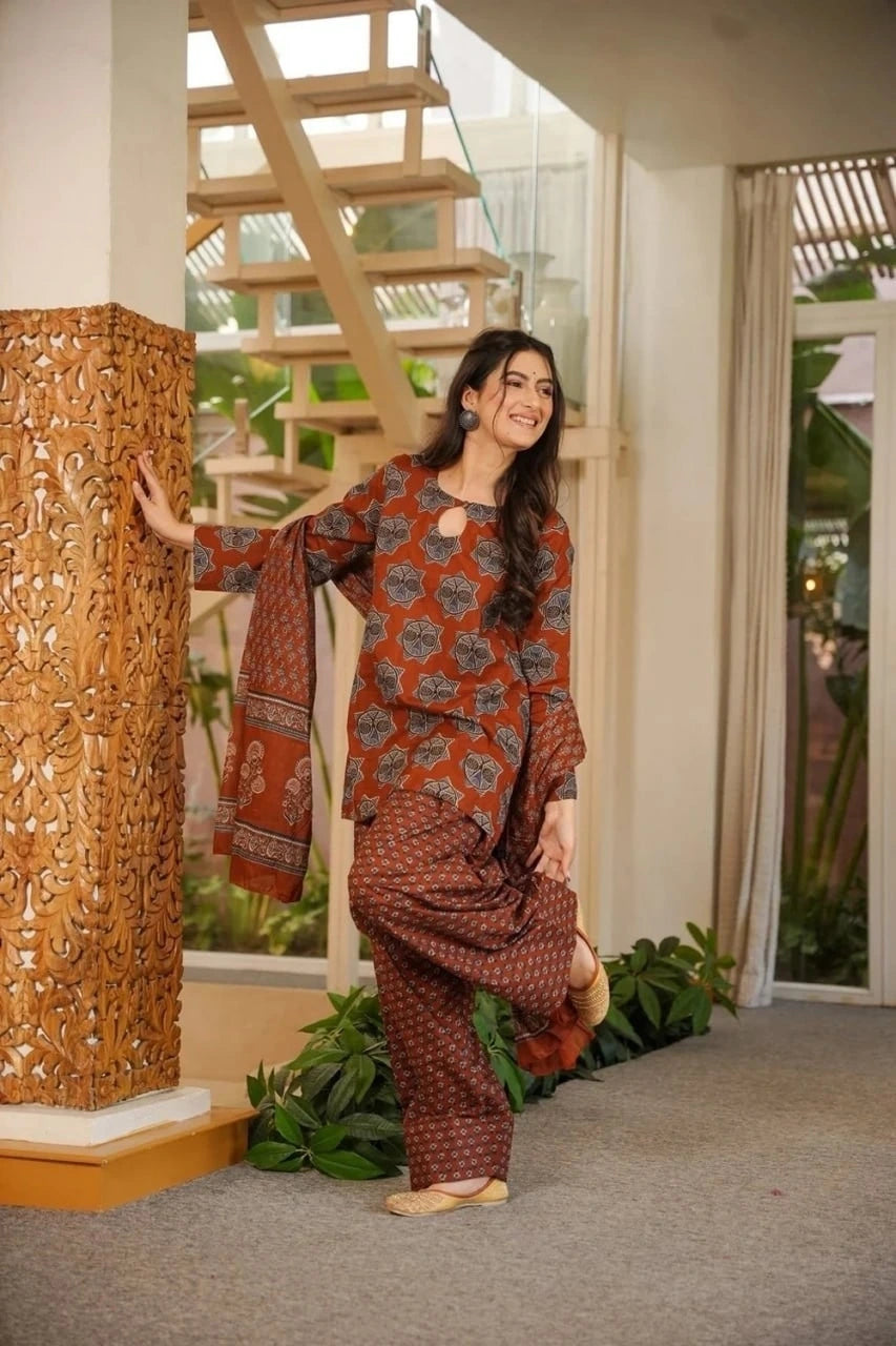 Woman in a traditional outfit standing in a room with decorative elements.