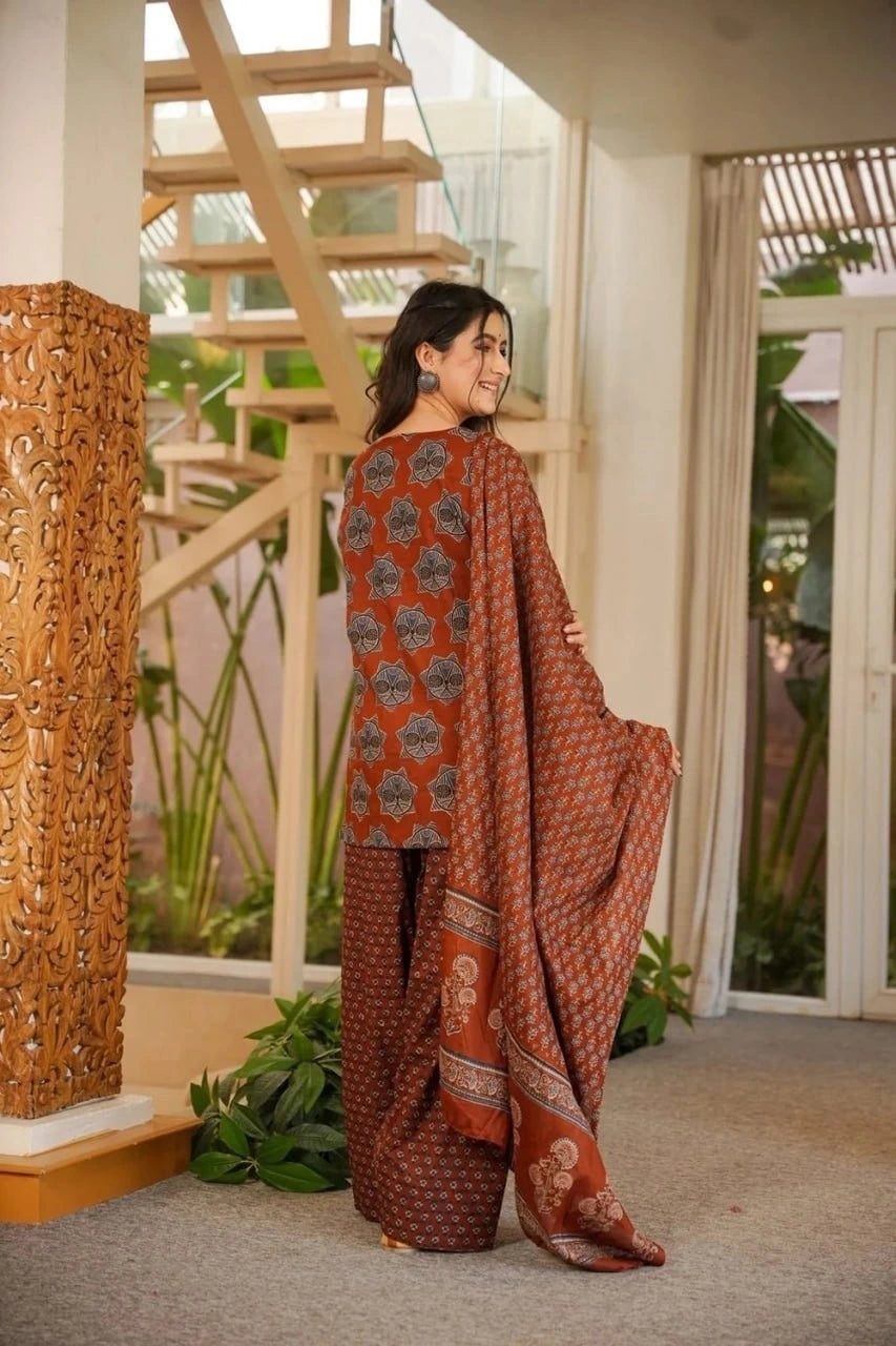 Woman in a patterned outfit standing in a home interior with decorative elements.