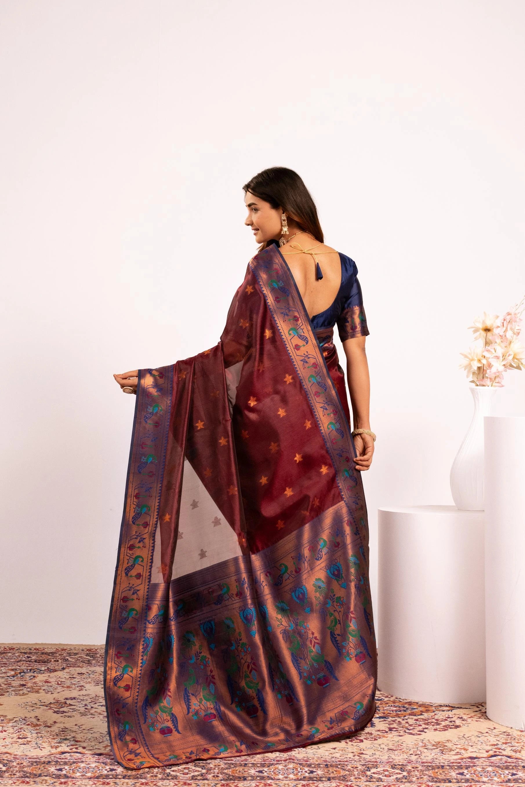 Woman wearing a traditional saree with a floral pattern on a white background