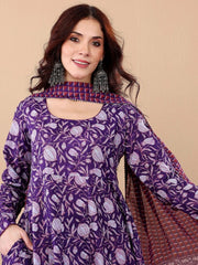 Woman wearing a purple patterned outfit with a beige background