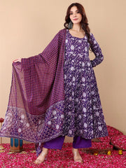 Woman wearing a purple patterned outfit with a matching dupatta on a beige background