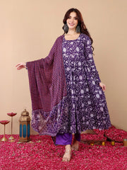 Woman wearing a purple floral outfit with a matching dupatta on a decorated floor.