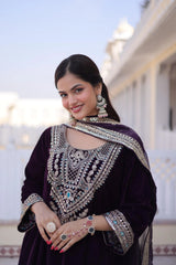 Woman in traditional attire with jewelry, standing outdoors.