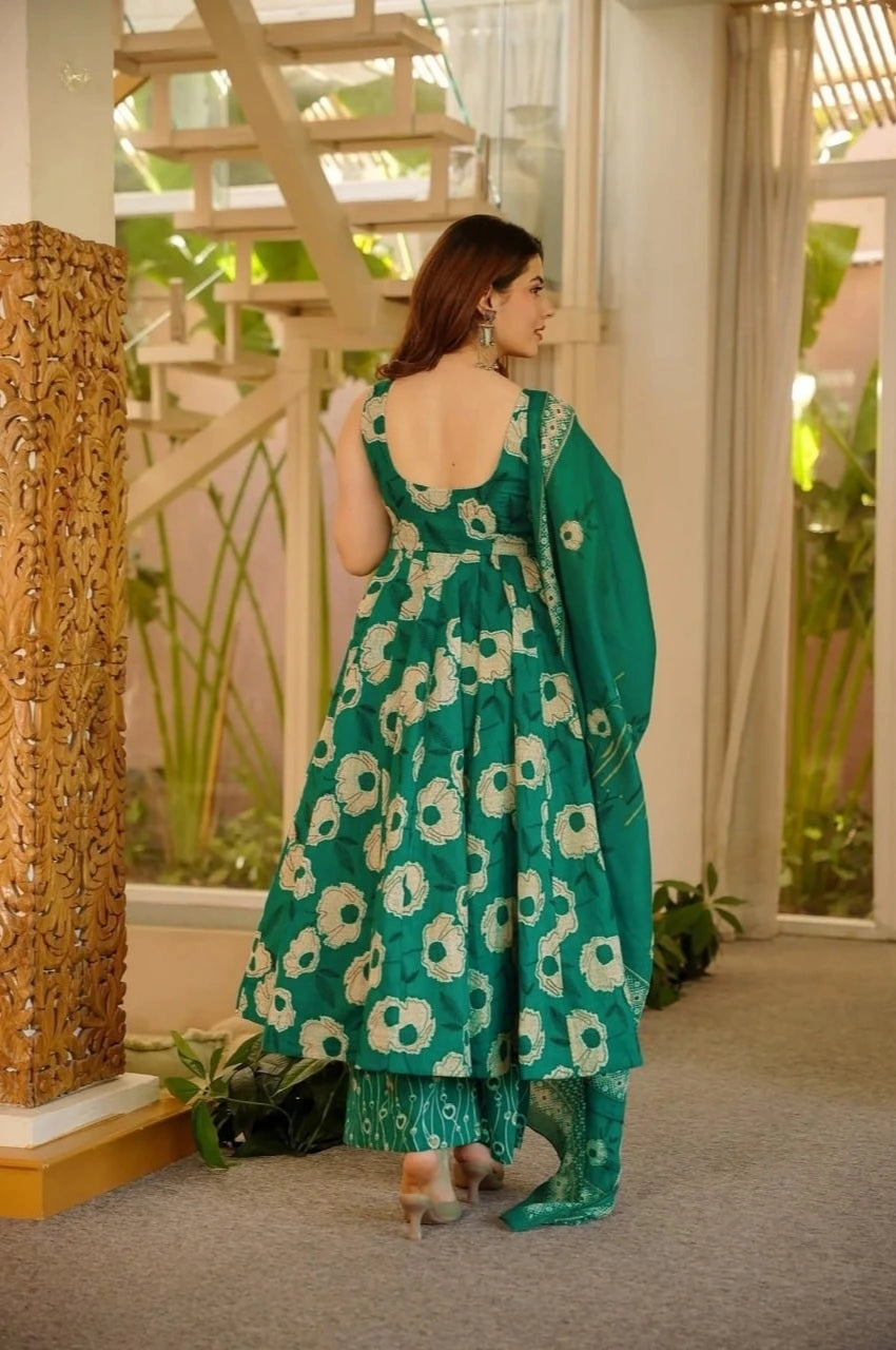Woman wearing a green floral dress in an indoor setting with decorative elements.