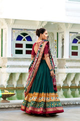 Woman in traditional Indian saree standing in front of a decorative building with a fountain.