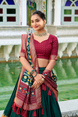 Woman in traditional attire standing by a pool with a decorative background
