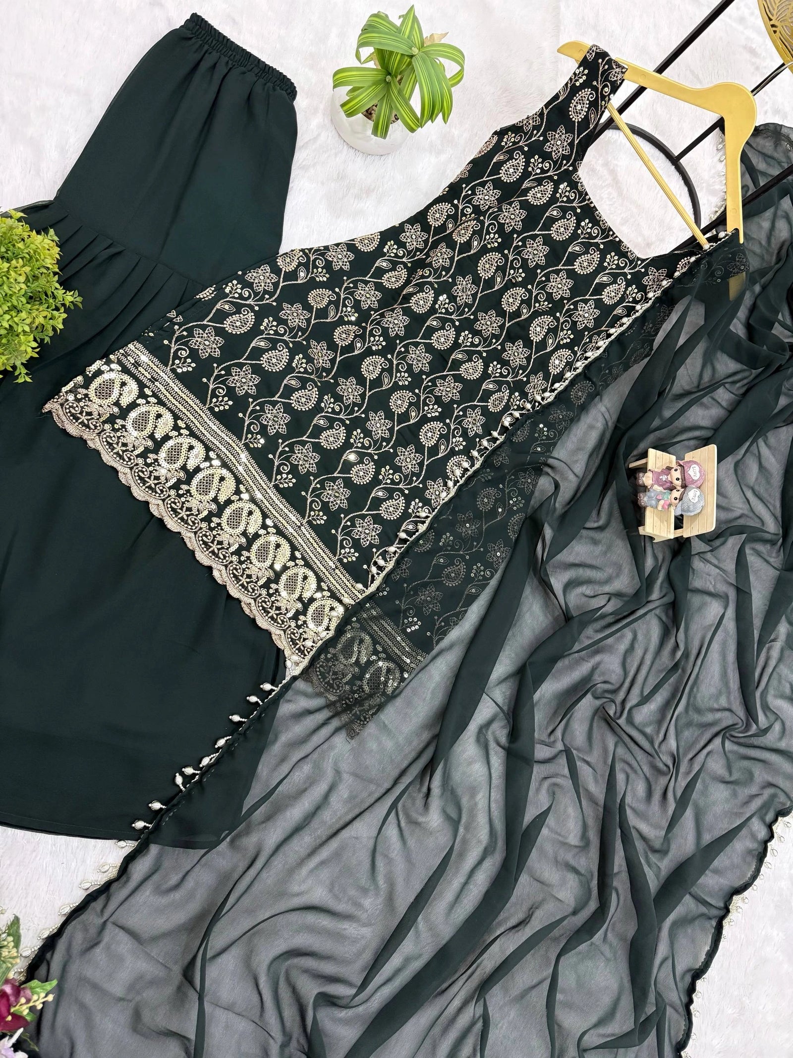 Black embroidered top with a gray saree draped over it on a white background.