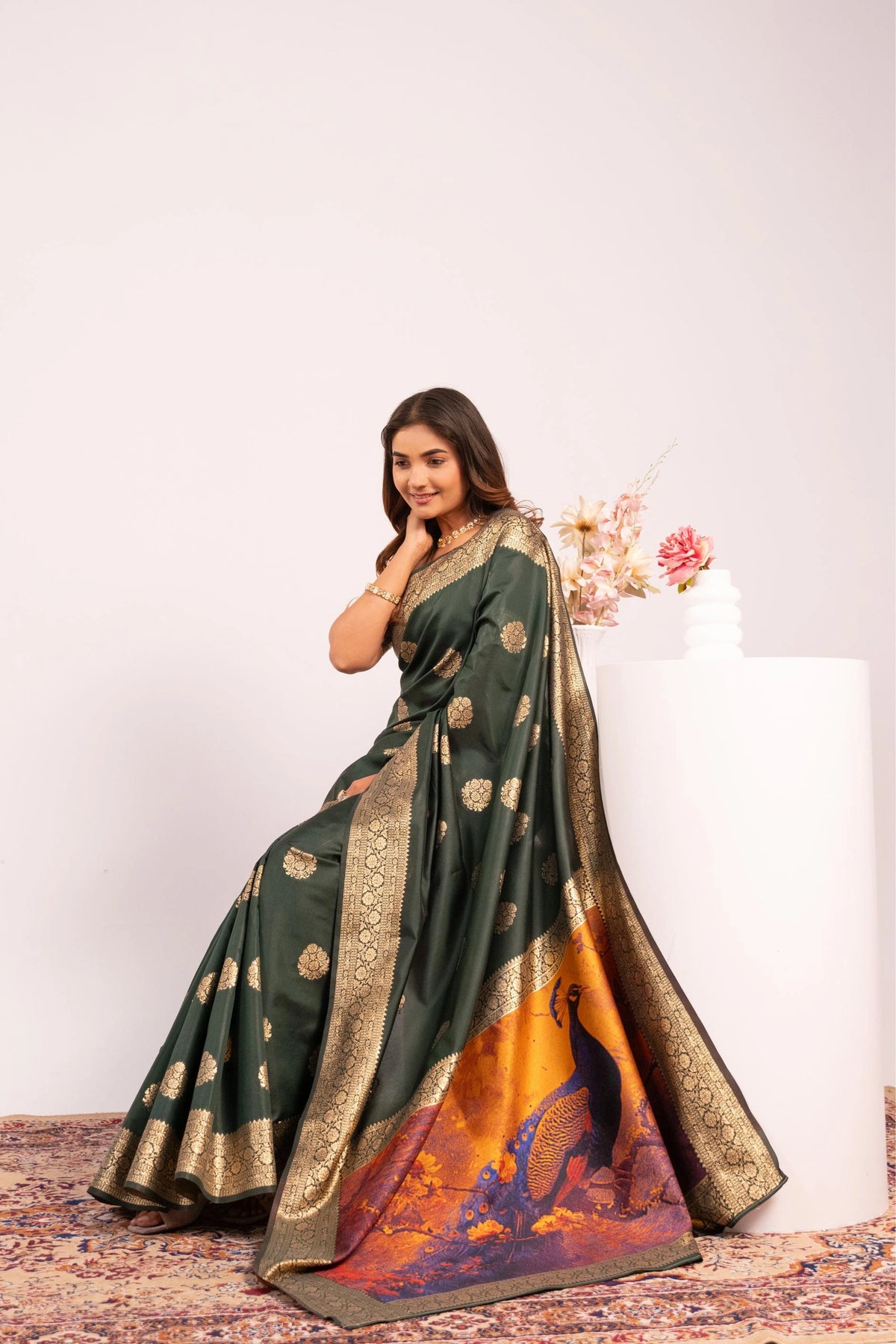 Woman wearing a traditional saree with a colorful pattern on a white background