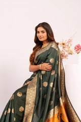 Woman wearing a green saree with gold patterns on a white background