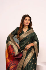 Woman wearing a dark green saree with gold and red patterns on a white background