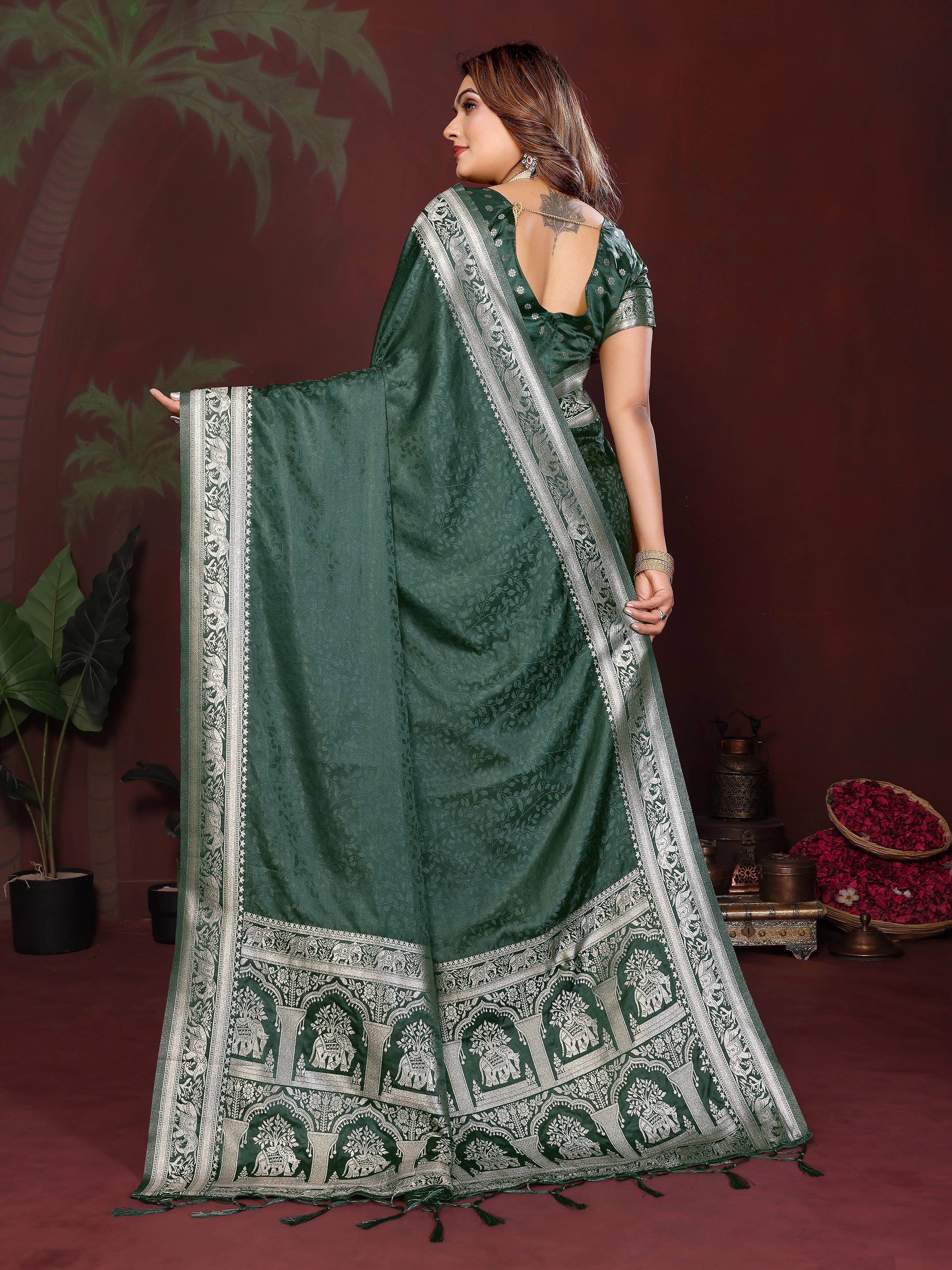 Woman wearing a green saree with white patterns against a dark background
