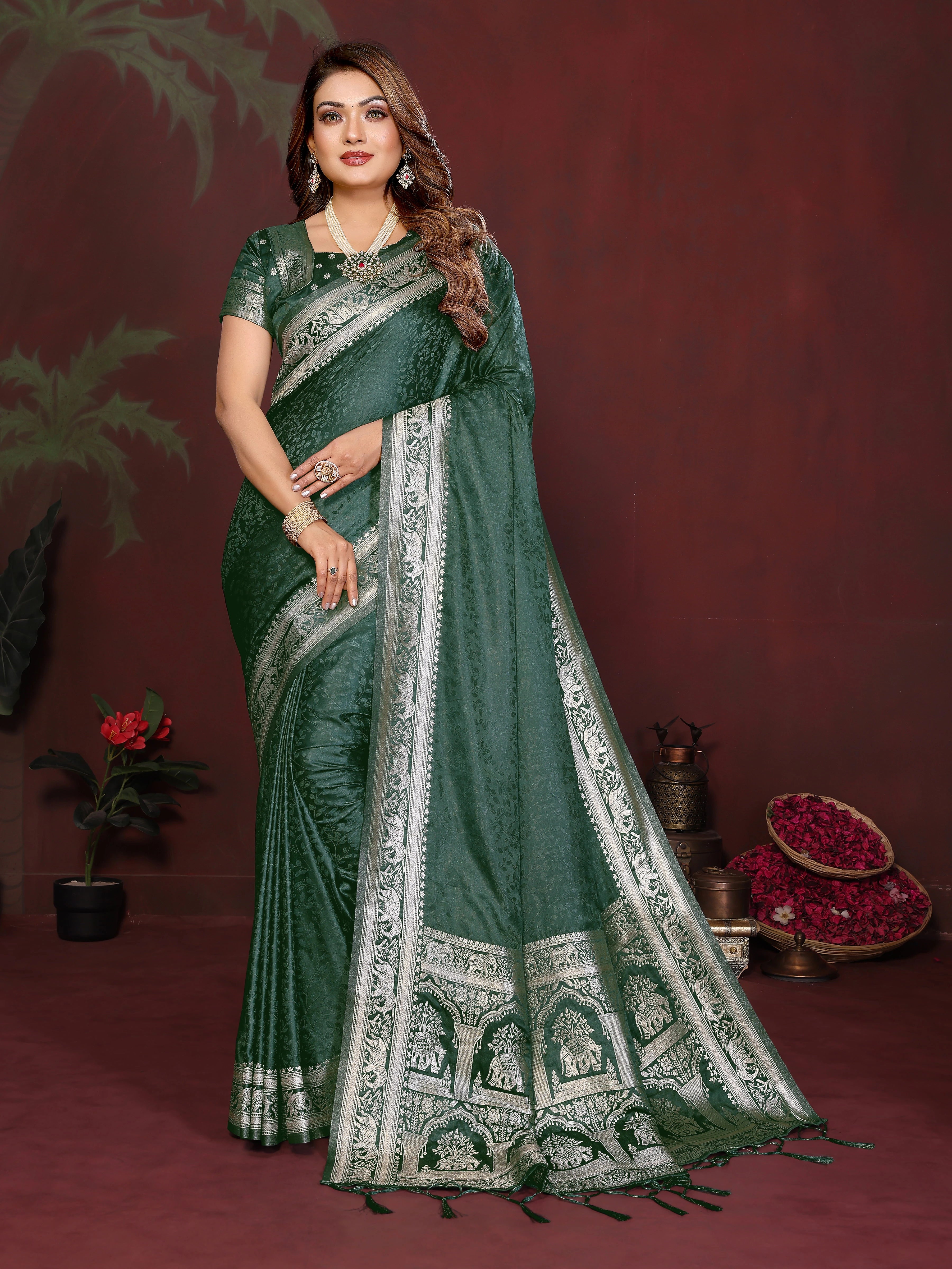 Woman wearing a green saree with white patterns on a dark red background