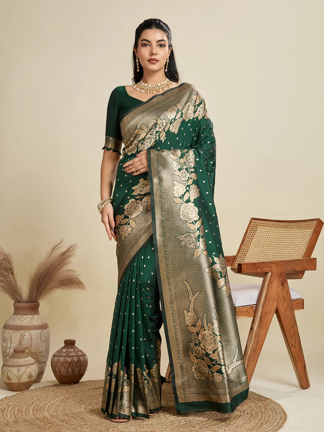 Woman wearing a green and gold saree with a beige background