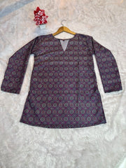 Purple patterned top on a hanger against a light background
