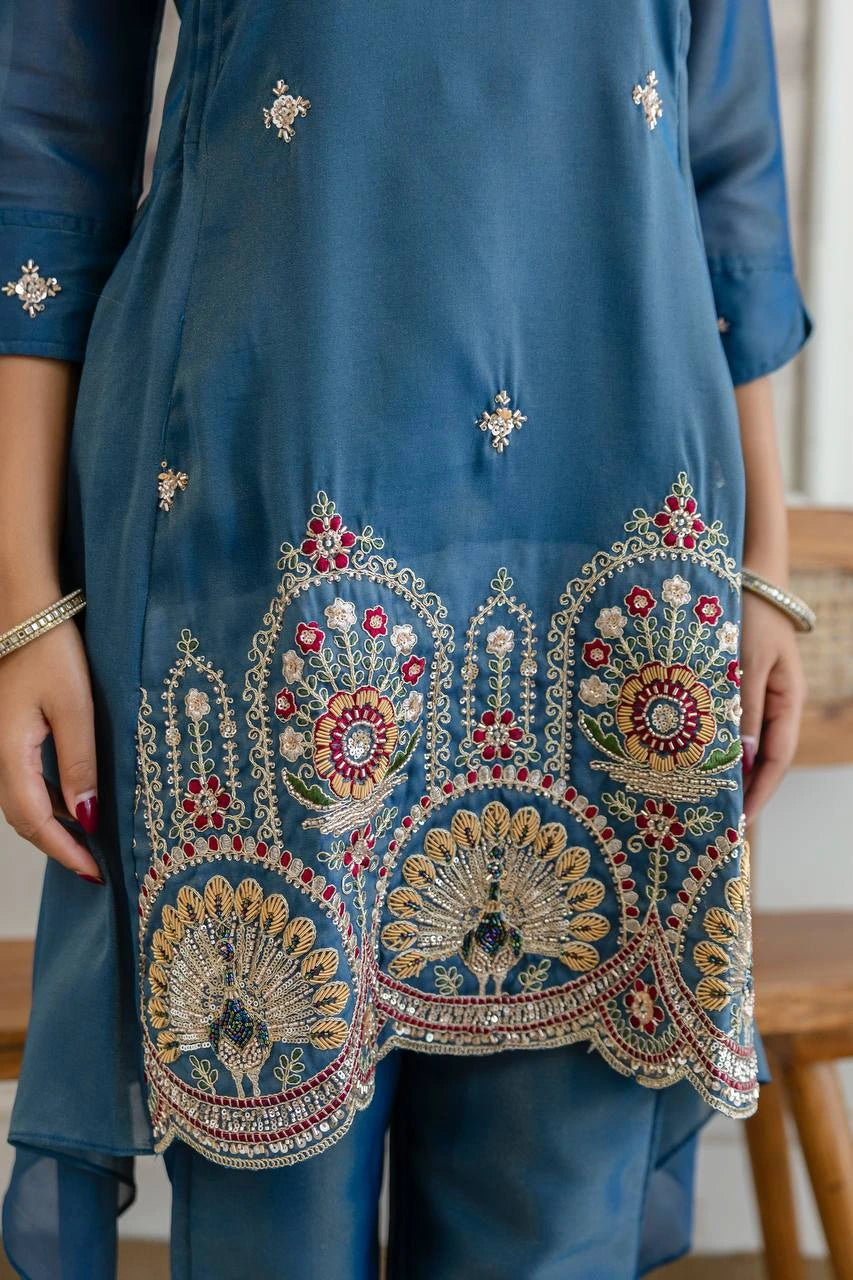 Blue embroidered outfit with intricate patterns on a blurred background