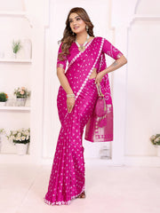 Woman wearing a pink saree with white patterns in a bright room.