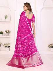 Woman wearing a pink saree with white patterns in a minimalistic setting