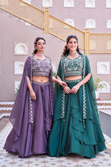 Two women in traditional outfits standing in a decorative indoor setting.