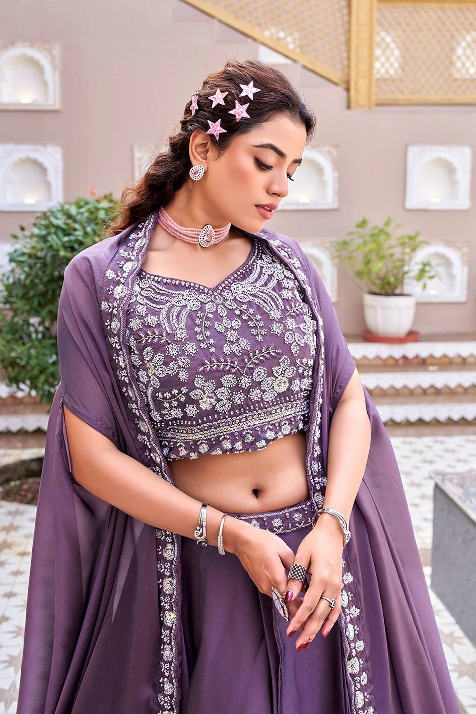 Woman in a traditional outfit with intricate patterns outdoors.