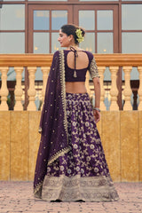 Woman in a purple traditional outfit with floral patterns standing on a wooden deck.