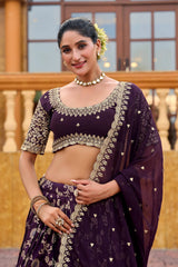 Woman wearing a traditional purple outfit with intricate designs outdoors.