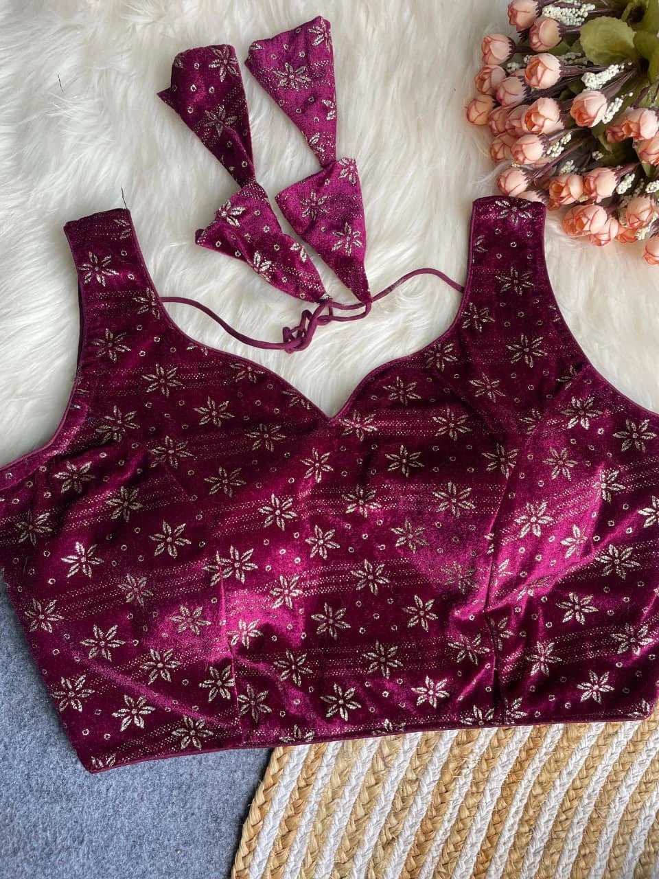Purple floral-patterned lingerie set on a textured surface with flowers in the background