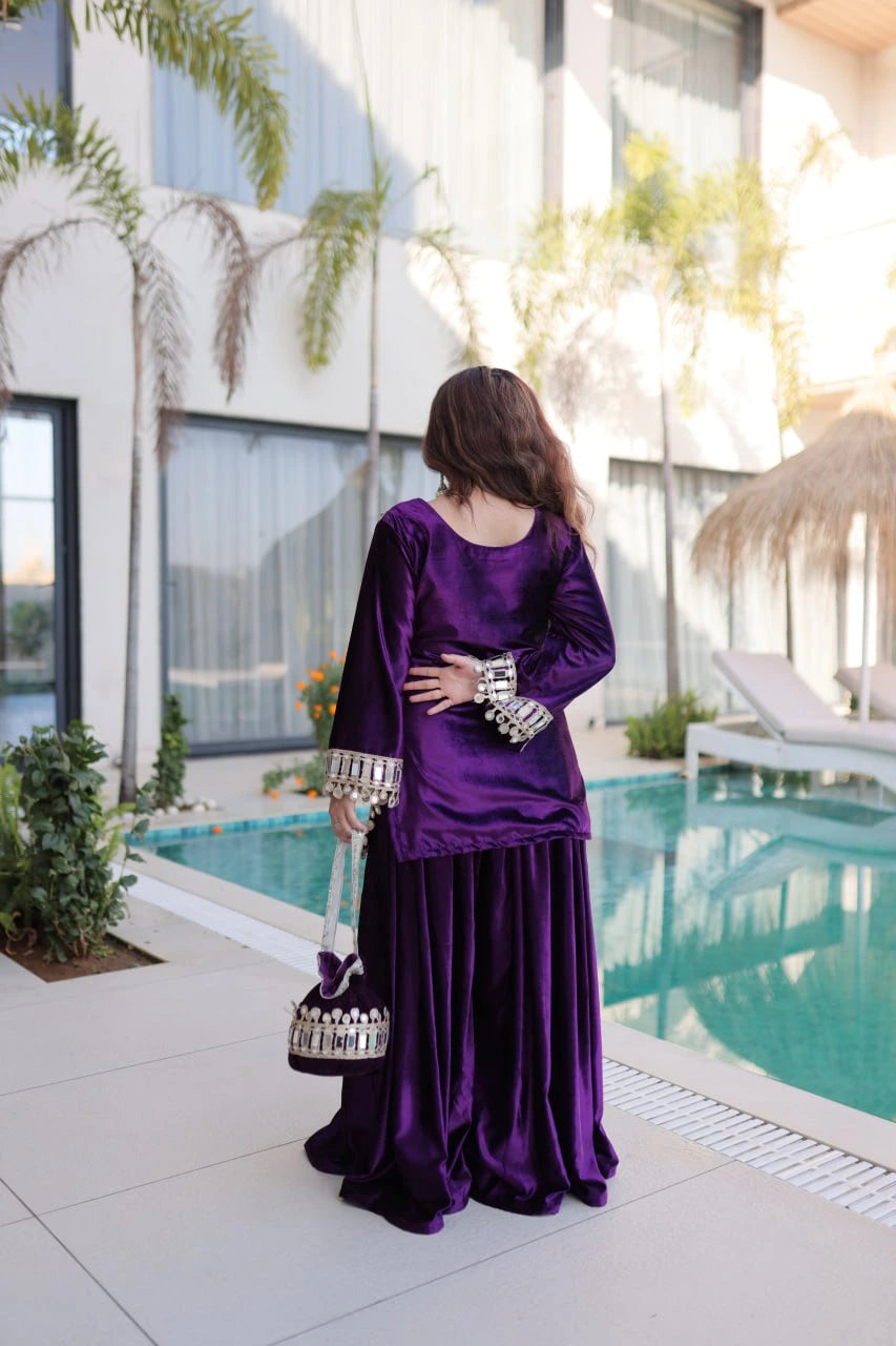 Woman in a purple traditional outfit standing by a pool with modern building in the background