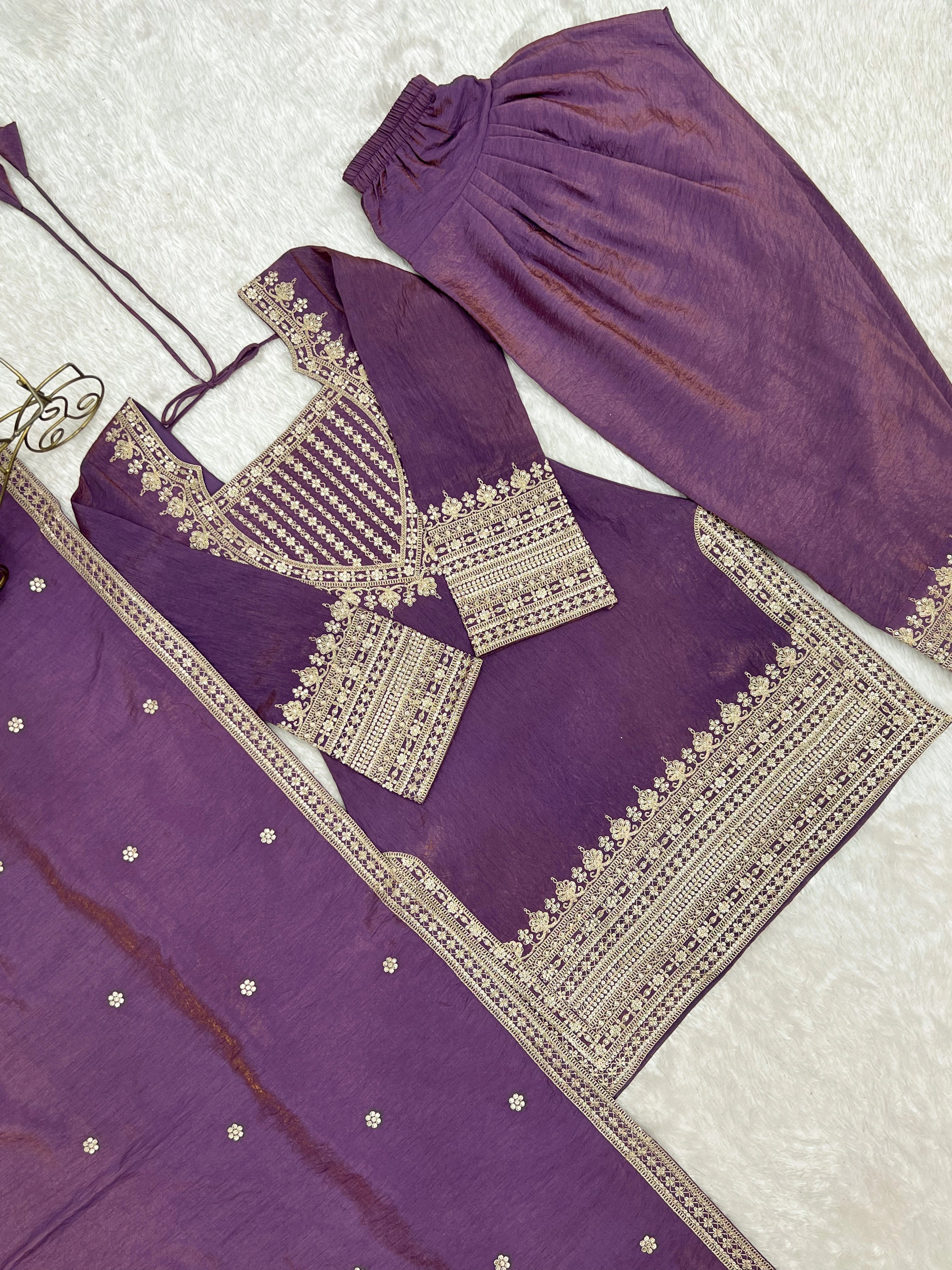 Purple traditional outfit with intricate silver embroidery on a white background