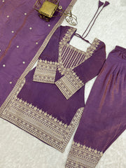 Purple traditional outfit with gold embroidery on a textured surface