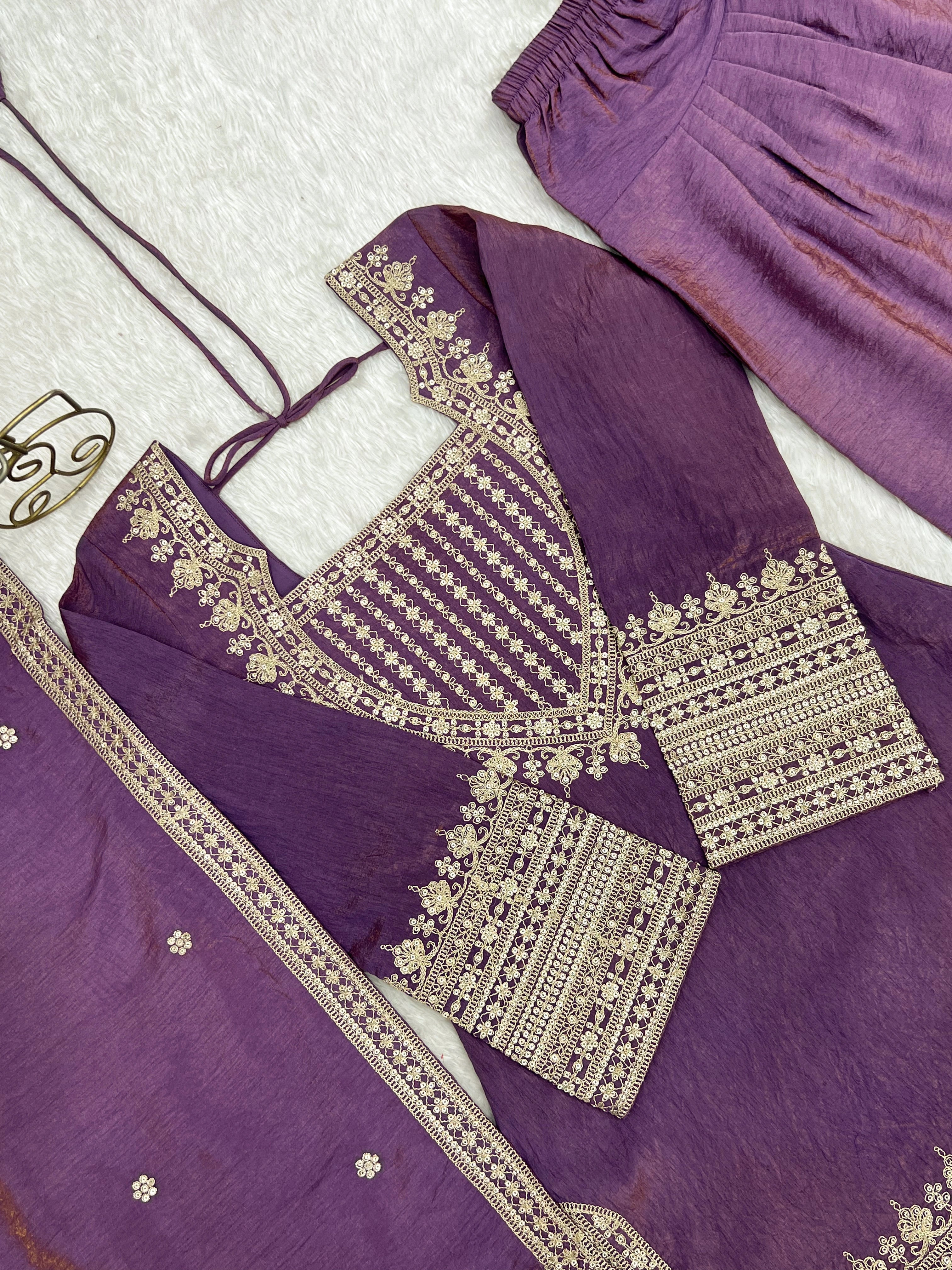 Purple traditional outfit with gold embroidery on a white background