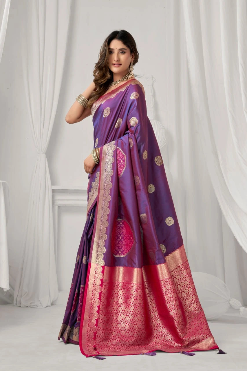 Woman wearing a purple and pink saree with a white curtain background