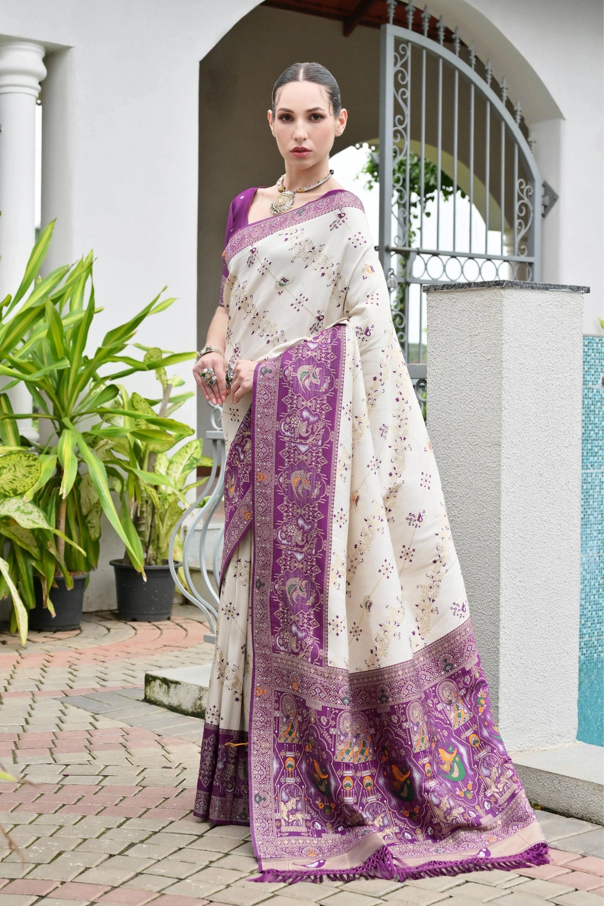 Close-up of deep purple silk saree highlighting shimmering golden zari craftsmanship.