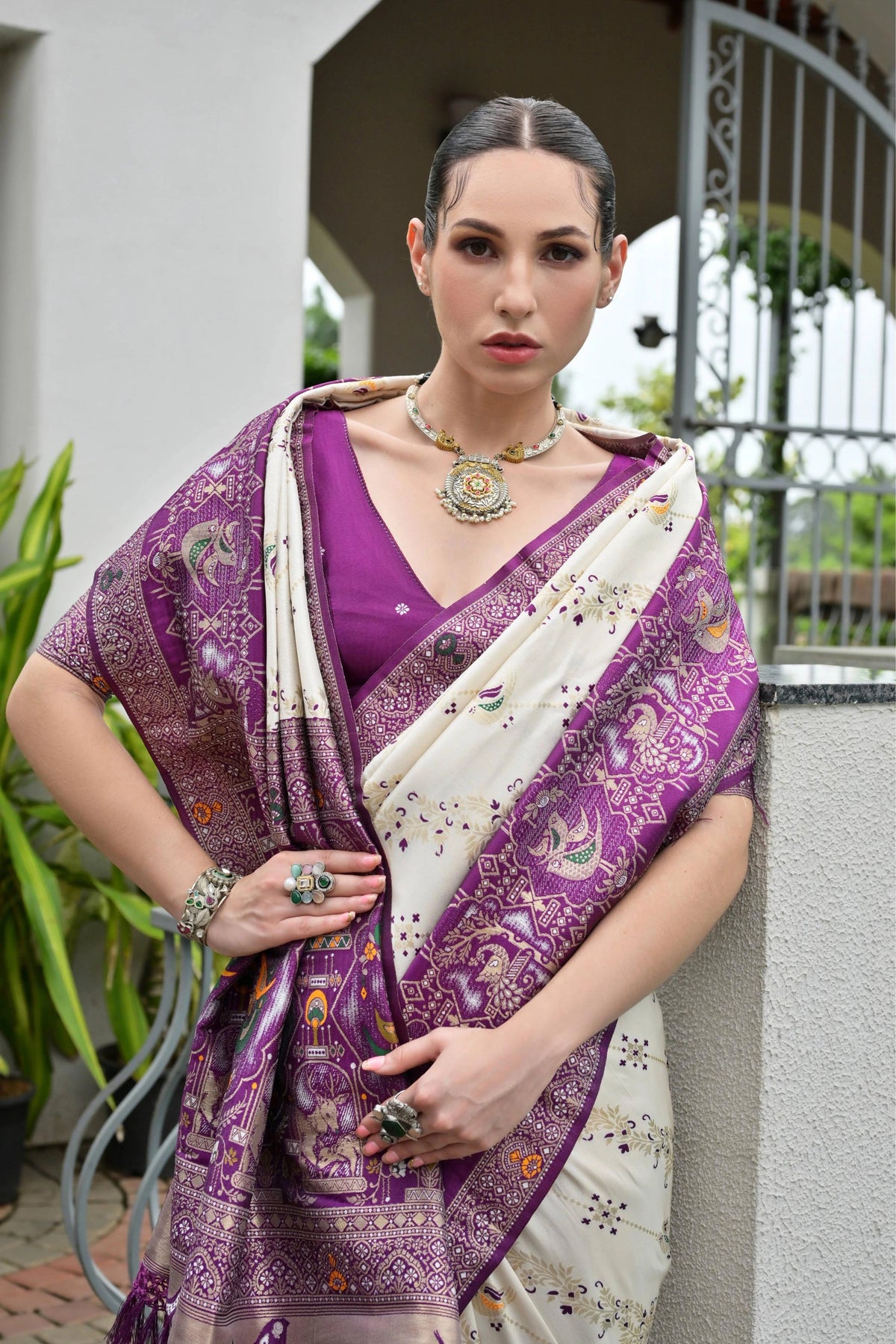 Deep purple Banarasi silk saree with golden zari weaving displayed on mannequin