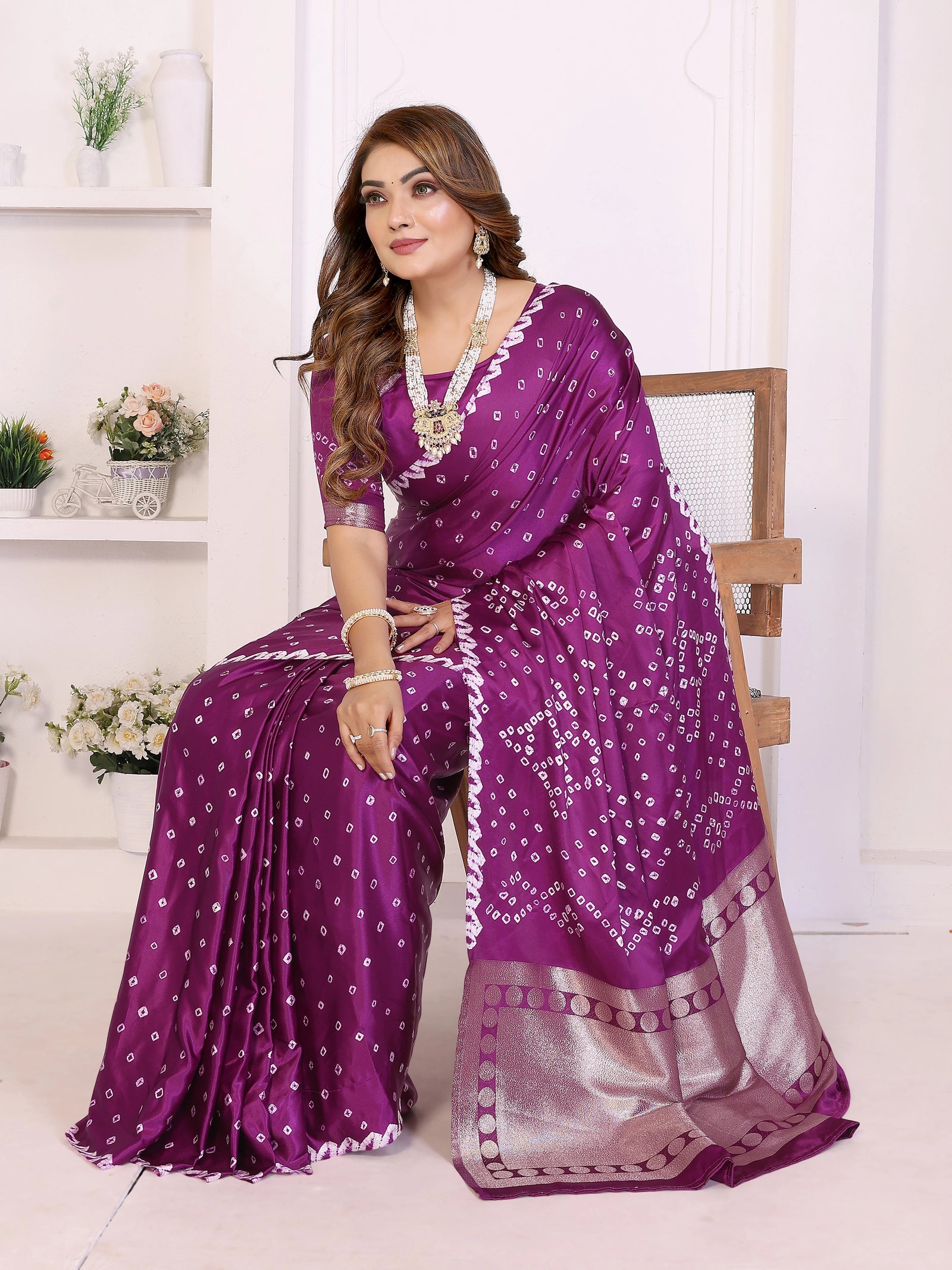 Woman wearing a purple saree with a white background