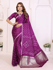 Woman wearing a purple saree with white patterns in a white room.