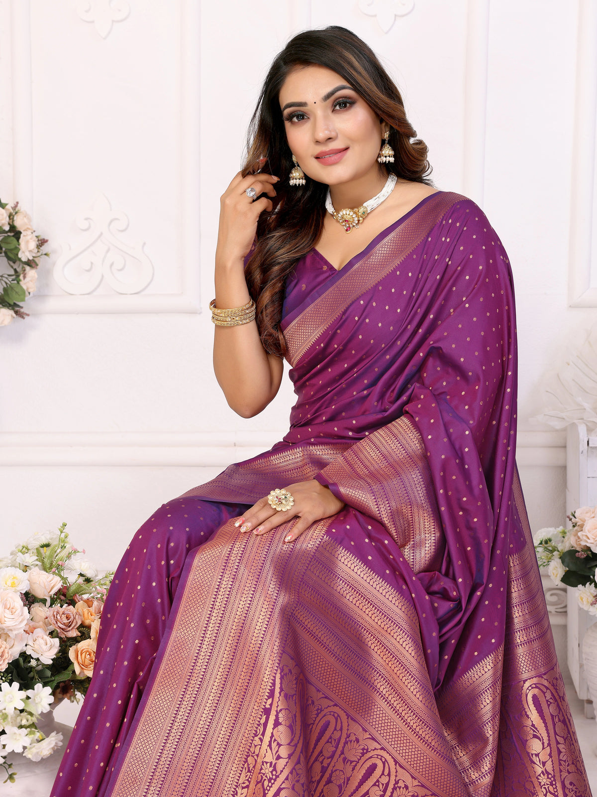 Woman wearing a purple saree with a white background