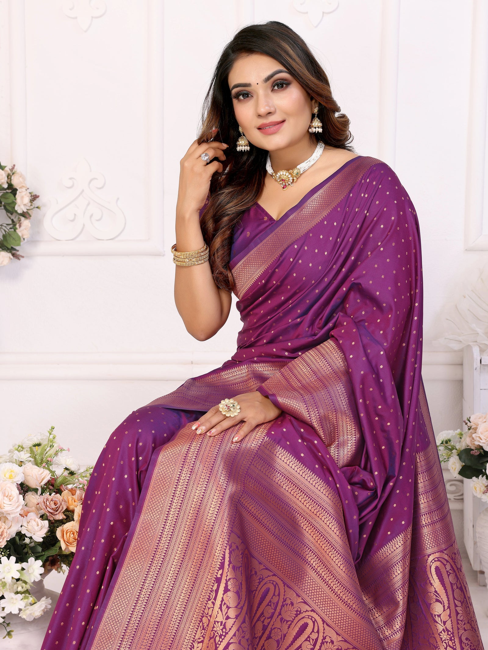 Woman wearing a purple saree with a white background