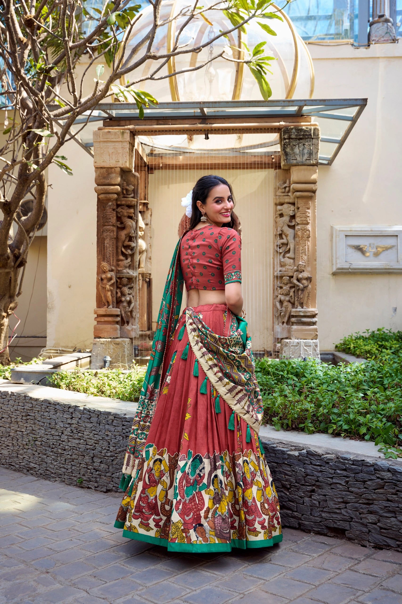 Women's maroon and green Kalamkari print saree with intricate traditional border and matching blouse.