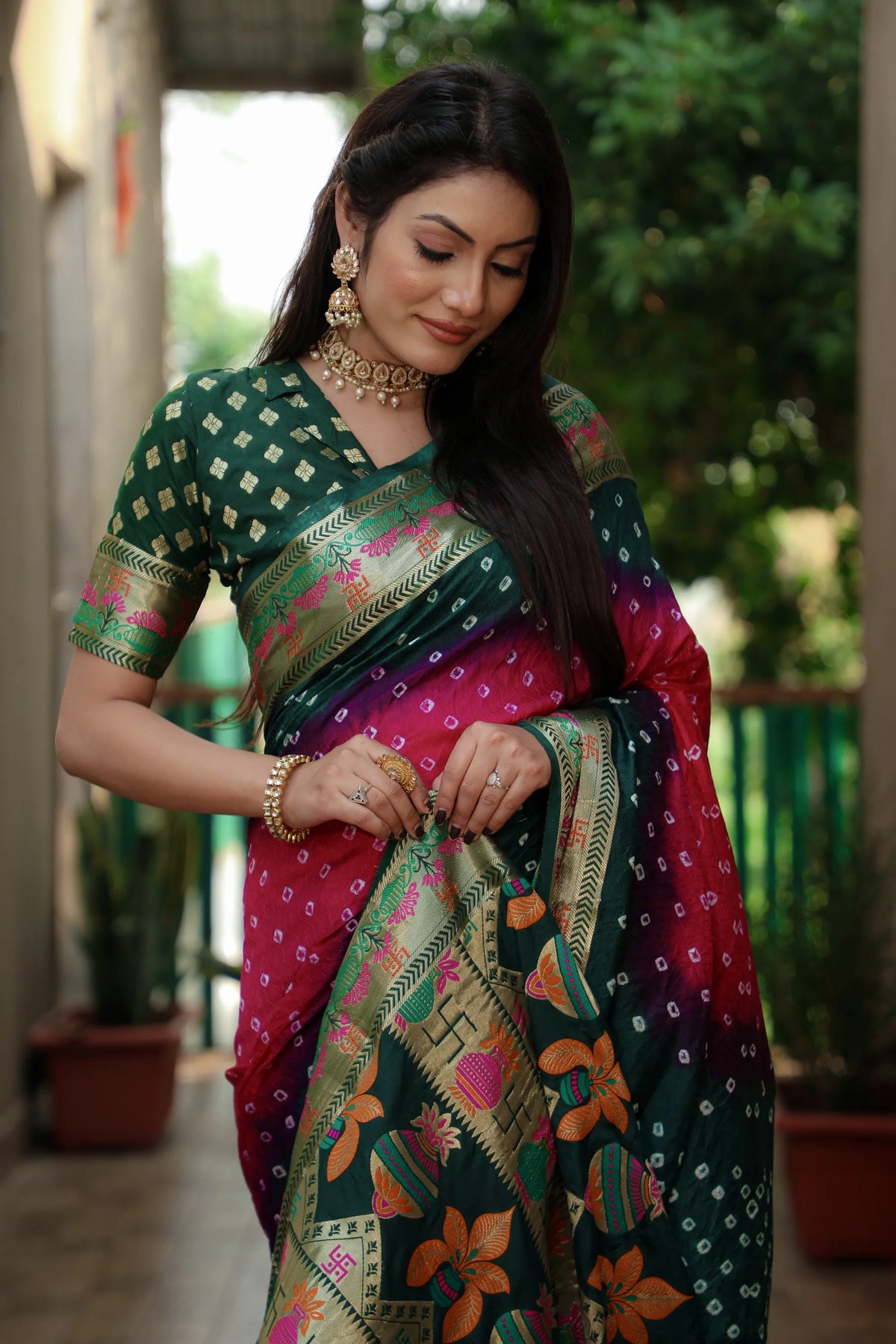 Woman in a colorful saree adjusting her fabric outdoors
