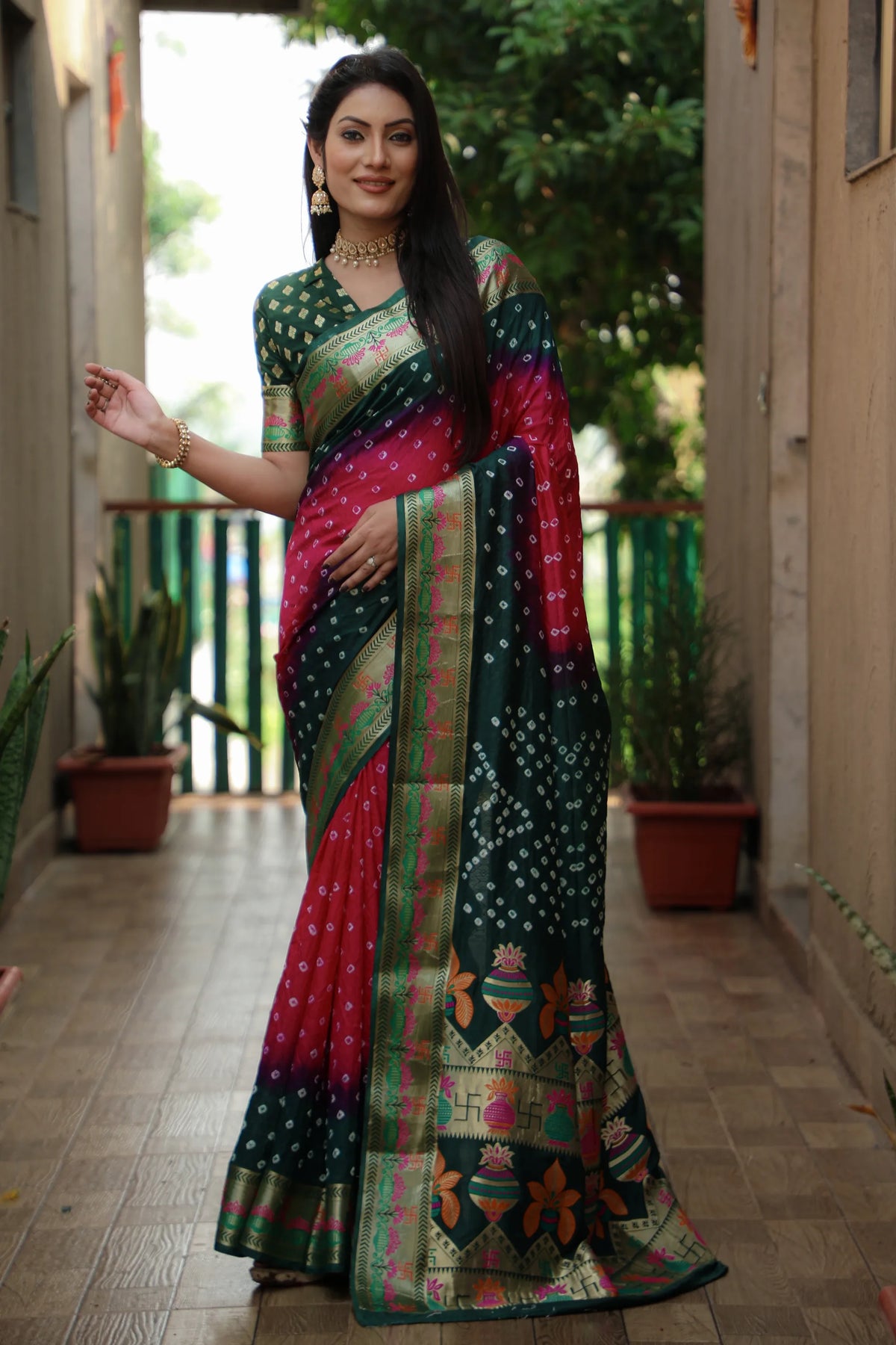 Woman wearing a colorful saree in an indoor setting with plants and a door in the background