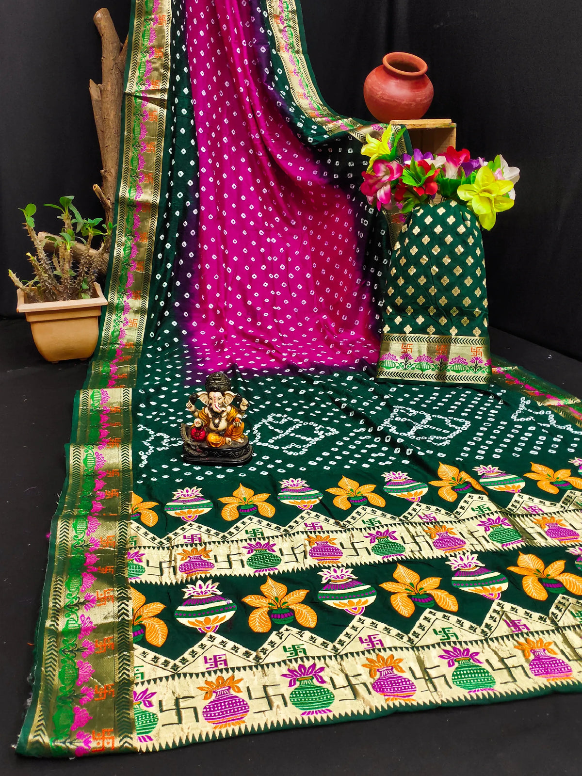 Traditional green and pink saree with decorative patterns on a black background