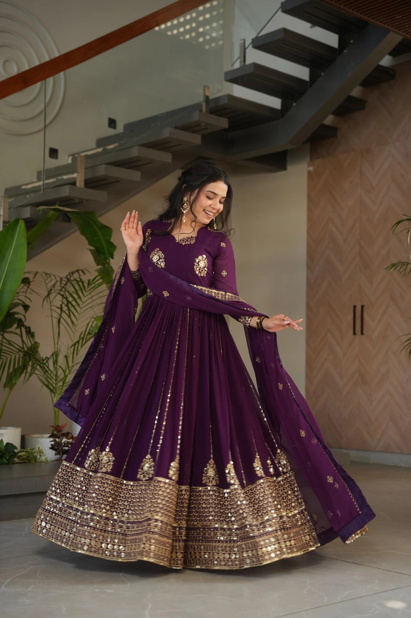 Woman in a purple traditional outfit with gold details in an indoor setting
