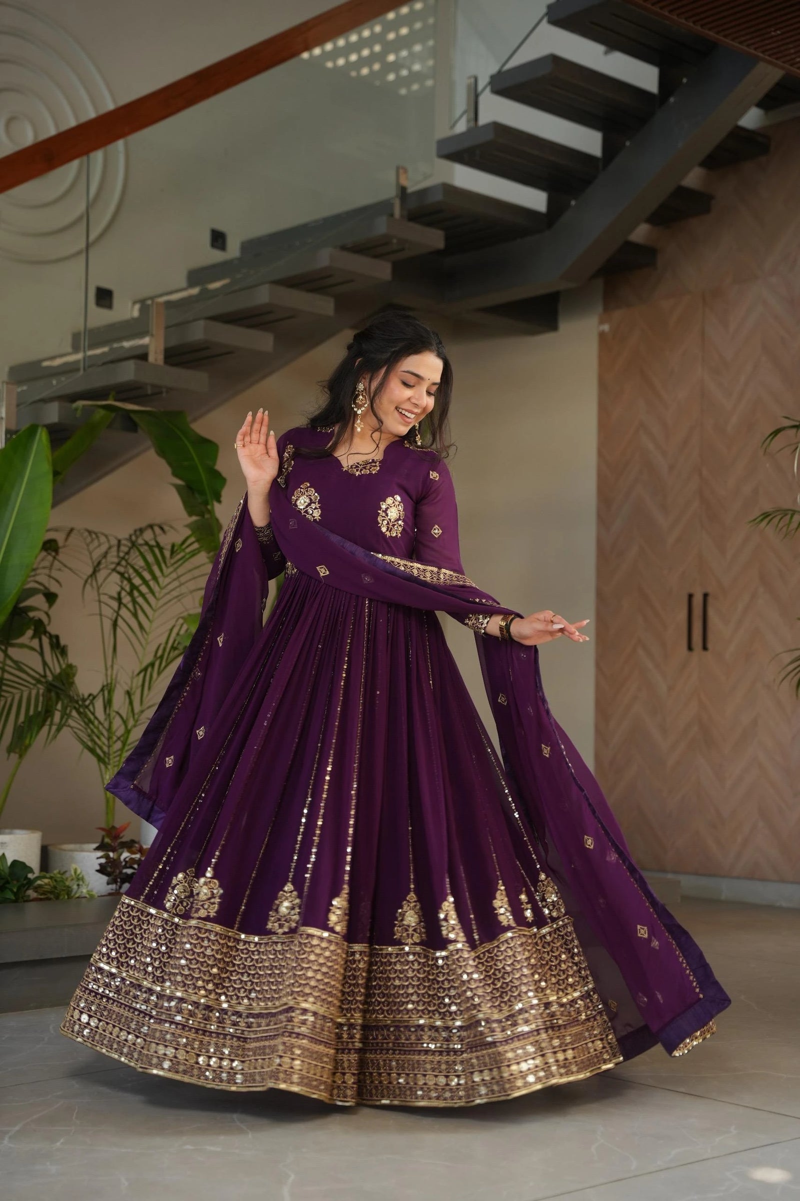 Woman in a purple traditional outfit with gold details in an indoor setting