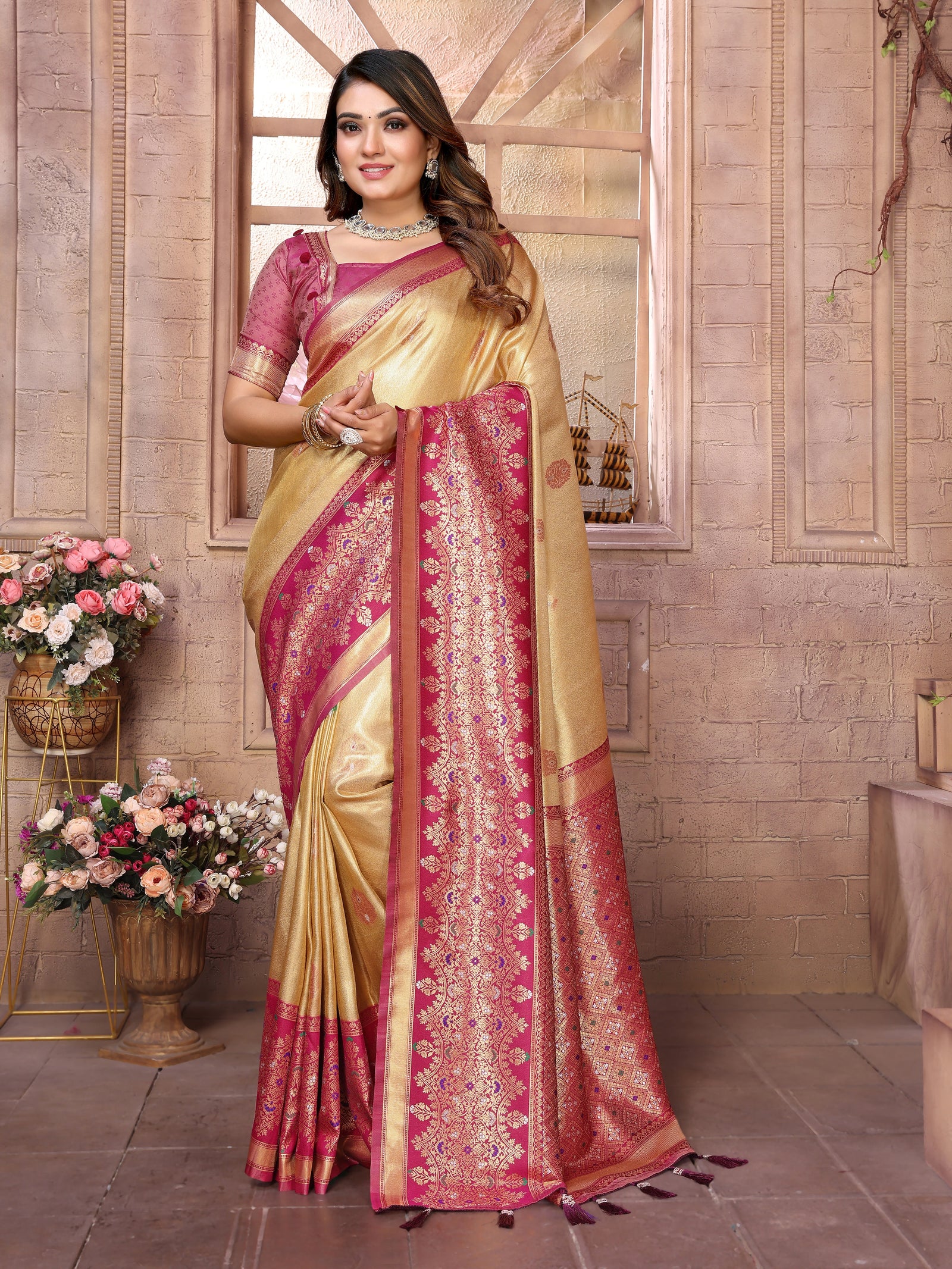 Woman wearing a traditional saree with a decorative border in a room setting.